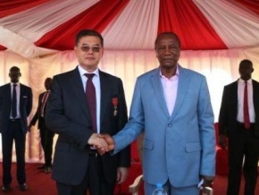 Le Président de la République de Guinée le Professeur Alpha Condé (d) et M. Sun Xiushun, Consul honoraire de la République de Guinée et Président de Winning International Group (g).